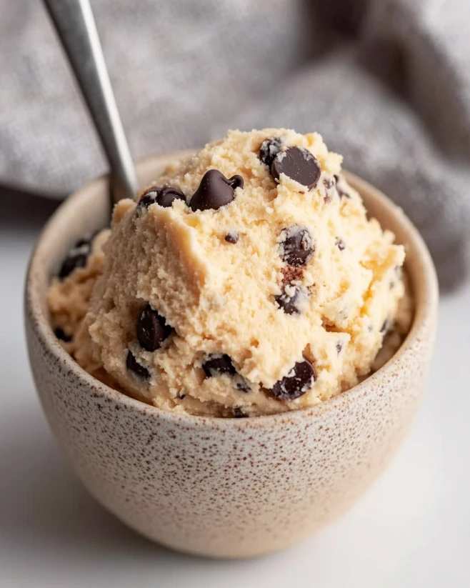 Cottage Cheese Cookie Dough Scoop in Bowl Scoop of cottage cheese cookie dough with chocolate chips in a rustic bowl