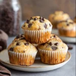 Protein Muffins That Actually Taste Good – Moist, Easy, And Healthy 2 Stack of golden chocolate chip protein muffins in white paper liners